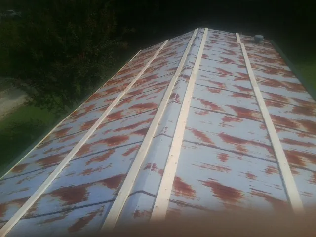 Rusted metal roof panels with new wood purlins before replacement — Storm Damage Roof Repair in Salt Point by Roofing Brothers